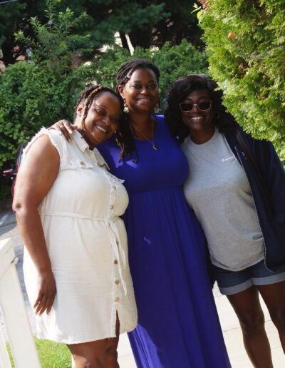 three young women standing on a sidewalk