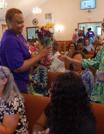 woman giving a flower bouquet to another woman